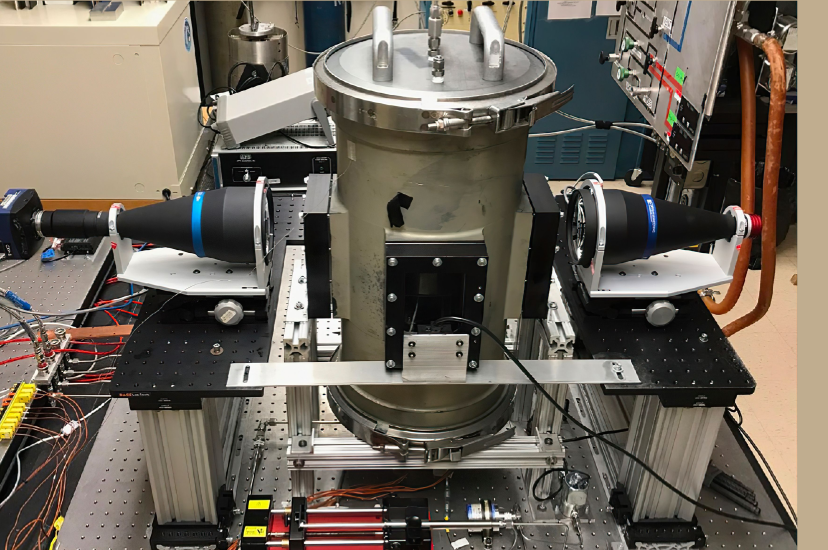 Two video cameras are positioned outside an experimental combustion chamber to capture the ignition and burning of fuel droplets (Image: NASA)