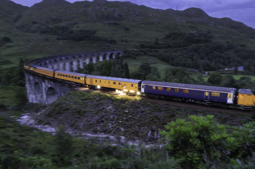 Network Rail ultrasonic test train fitted with machine vision sensor crossing the Glenfinnan Viaduct at dusk