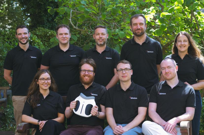 Employees sit outside and pose for a team photograph