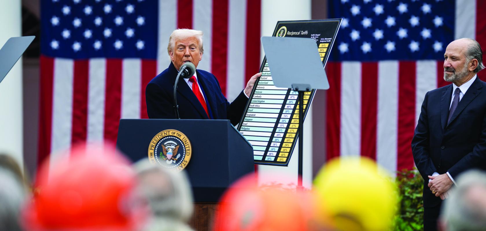 US President Donald Trump holding up a card of import tariffs