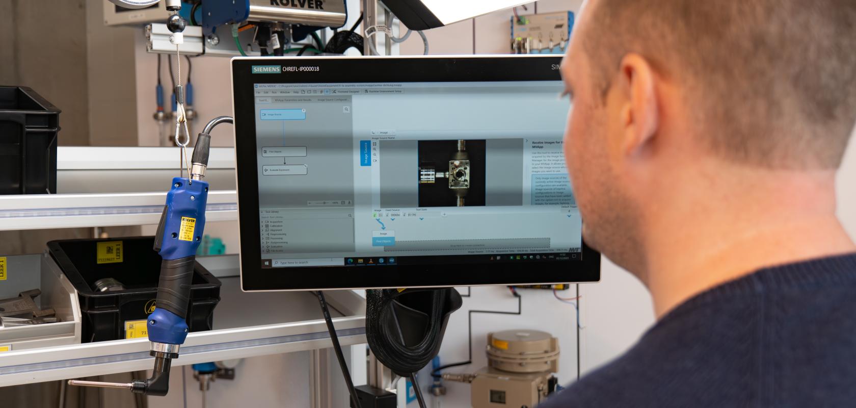 Manual assembly worker checks machine vision quality inspection system