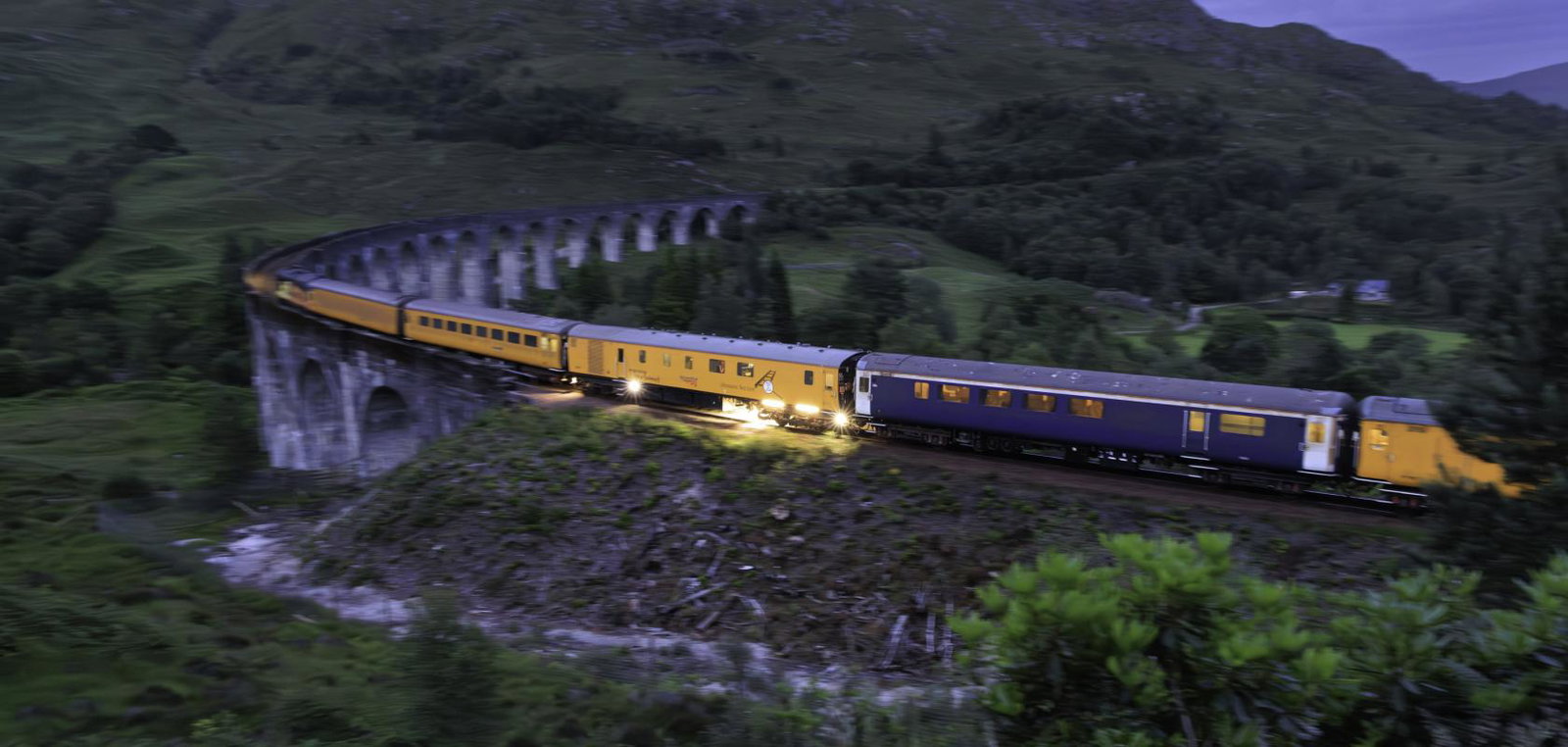 Network Rail ultrasonic test train fitted with machine vision sensor crossing the Glenfinnan Viaduct at dusk