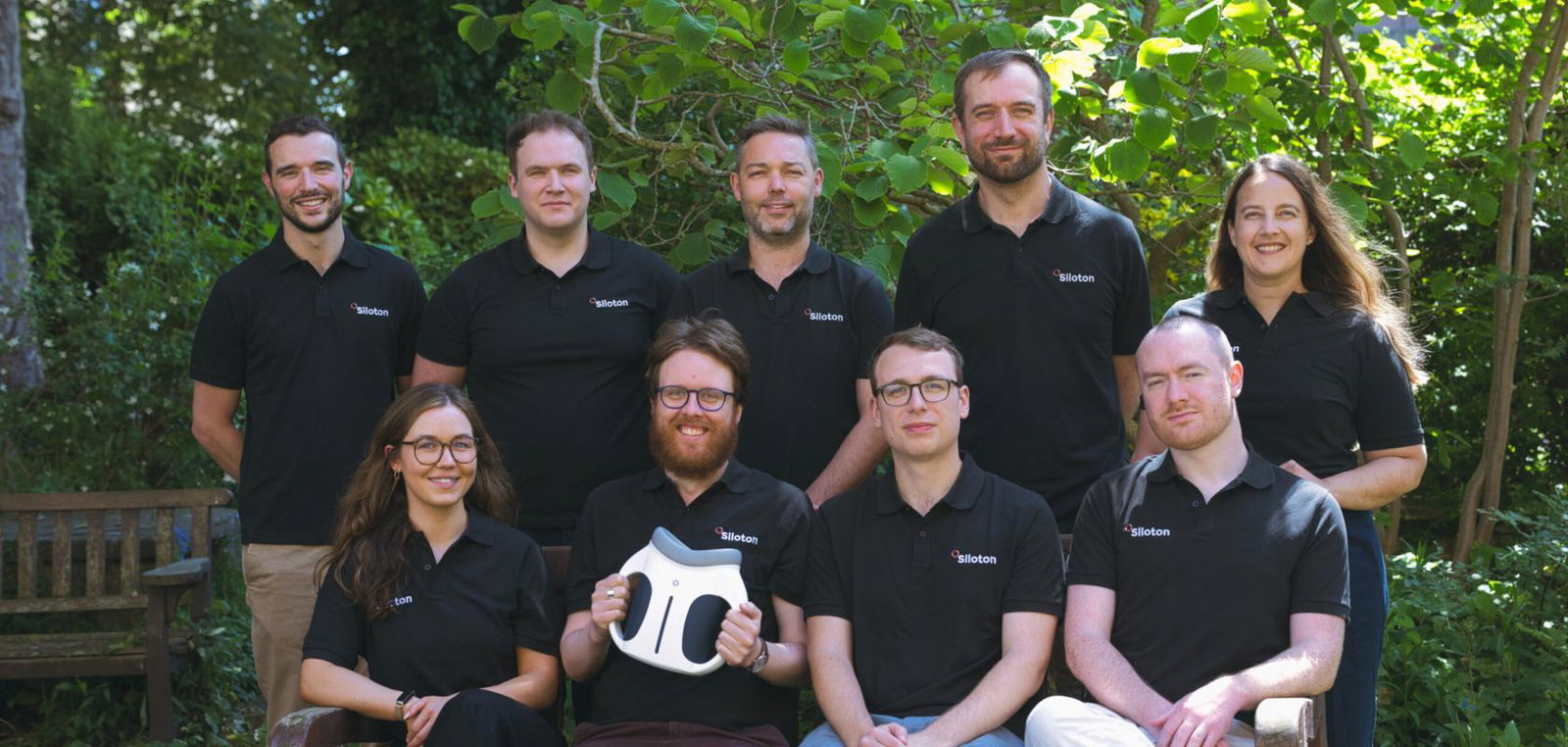 Employees sit outside and pose for a team photograph