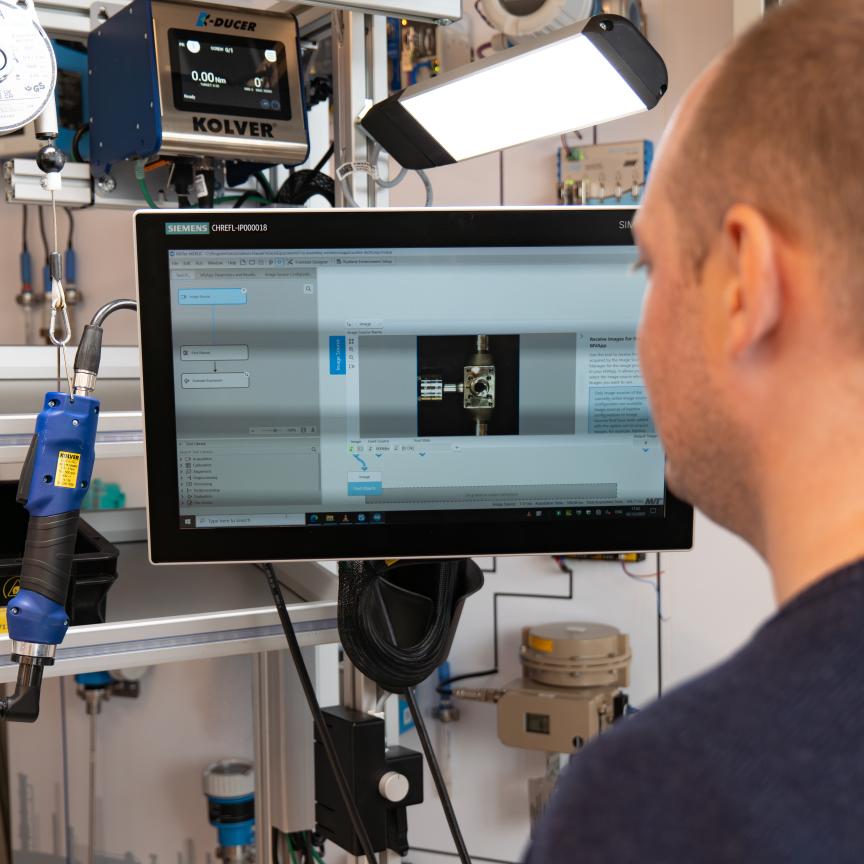 Manual assembly worker checks machine vision quality inspection system