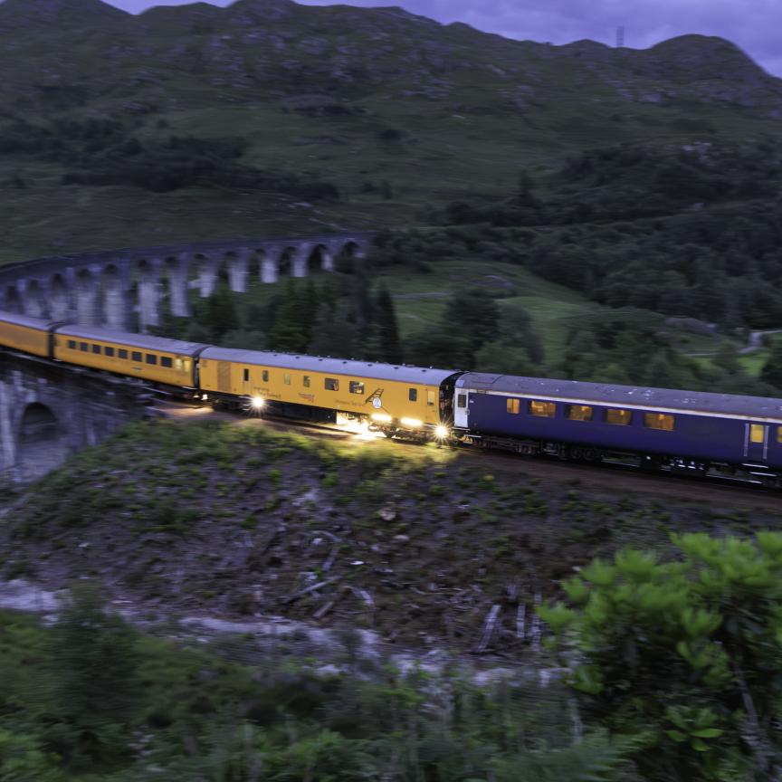 Network Rail ultrasonic test train fitted with machine vision sensor crossing the Glenfinnan Viaduct at dusk