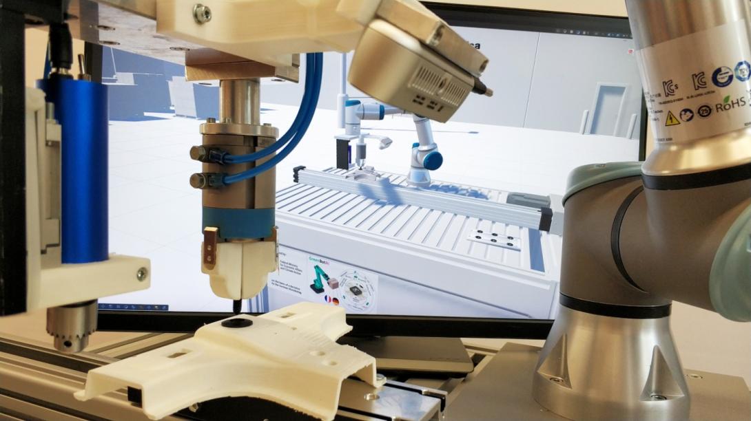 The robot picks up a clip and inserts it into a moving part